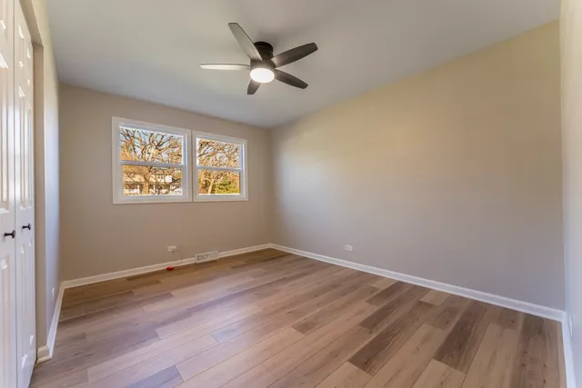 a front view of a house with a garden and trees