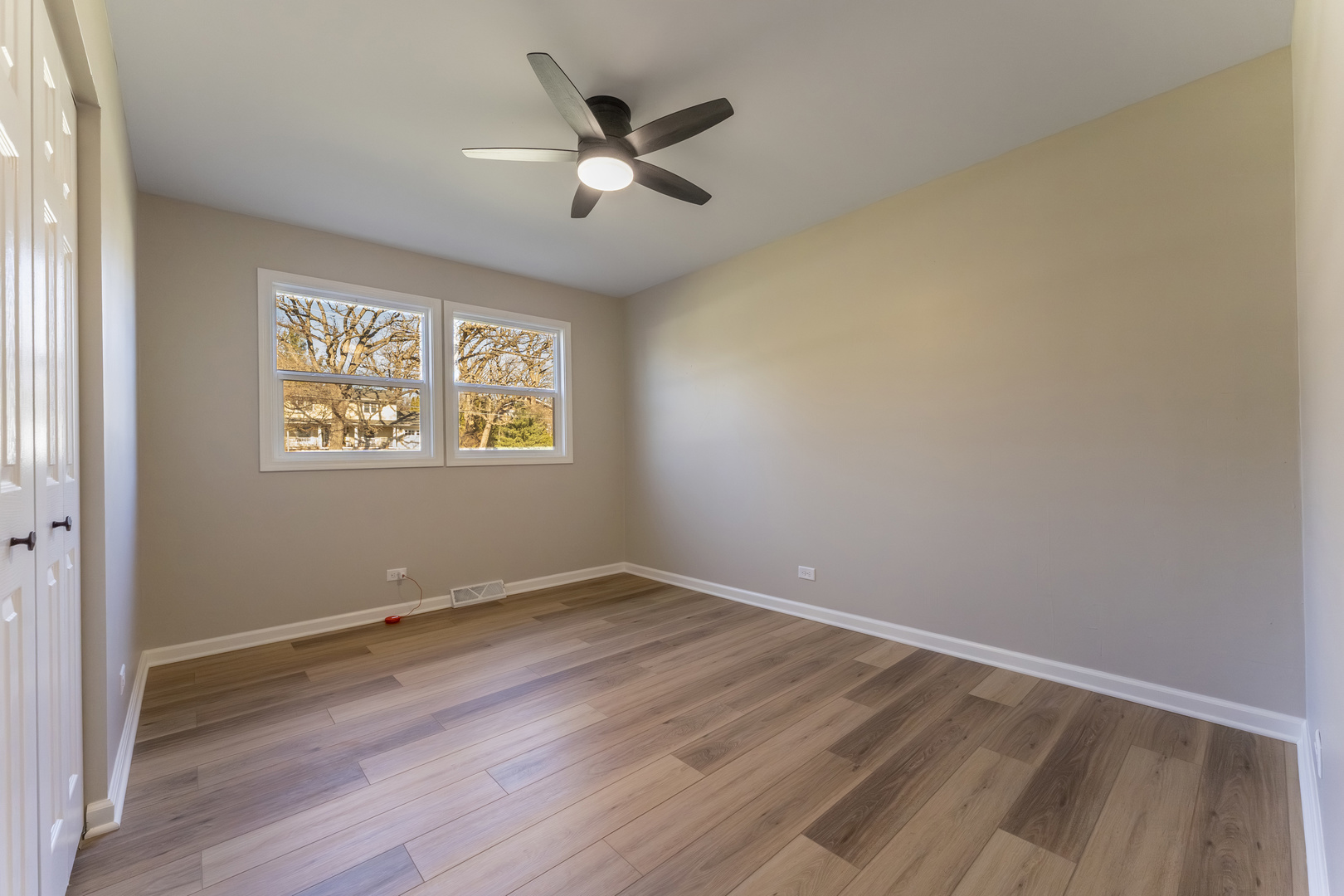 27-w073 Jewell Road Winfield, IL 60190 - Photo 13 of 34 an empty room with wooden floor chandelier fan and windows