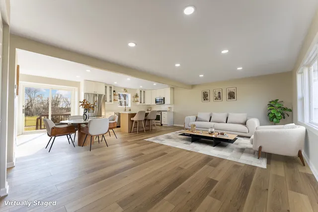 an empty room with wooden floor chandelier fan and windows