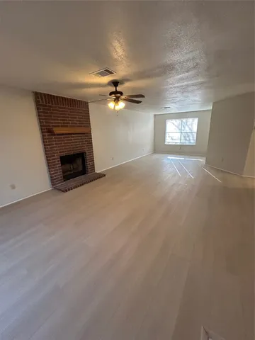 an empty room with windows and fireplace