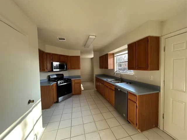 a kitchen with stainless steel appliances granite countertop a stove and a sink