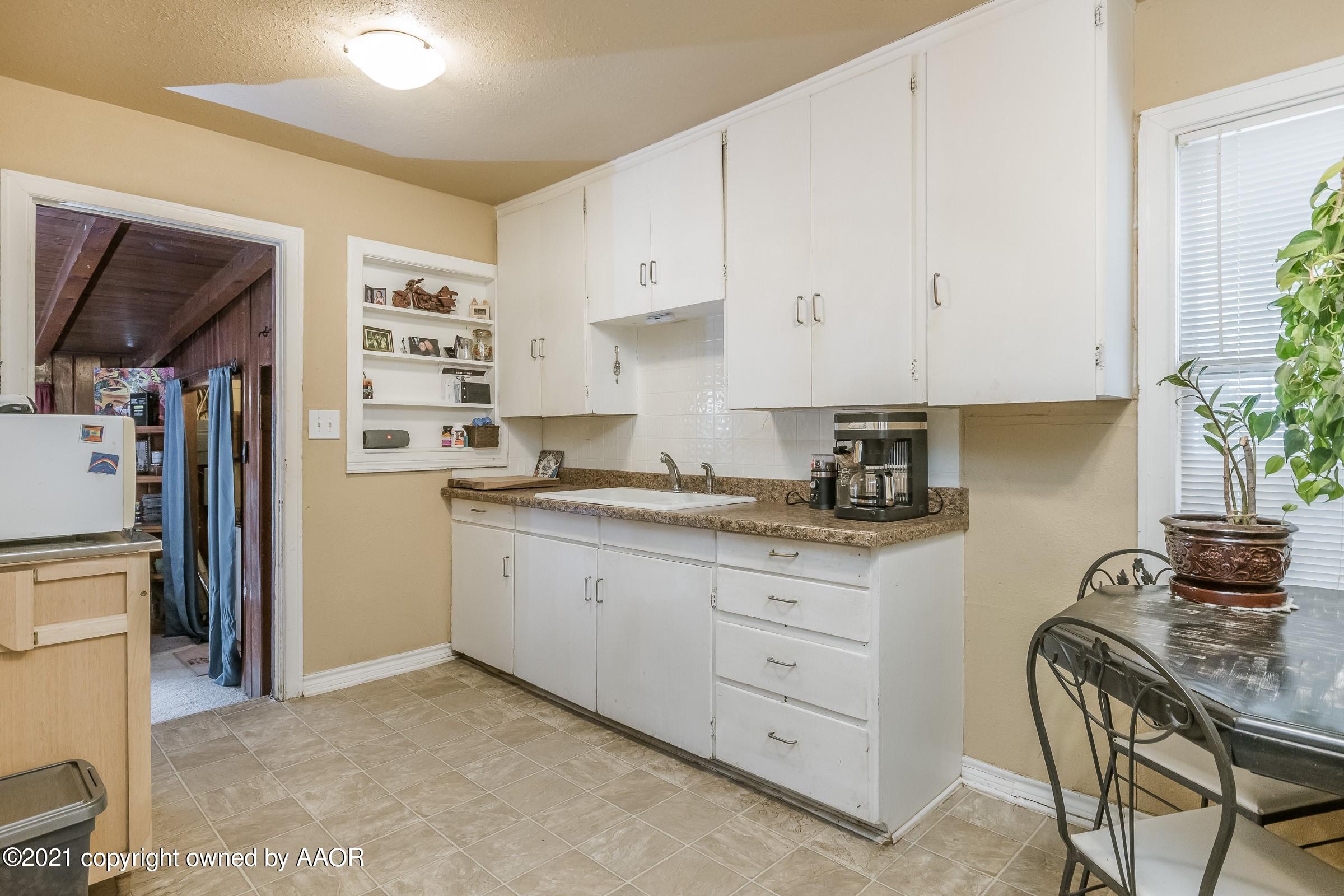 4100 South Ong Street Amarillo, TX 79110 - Photo 5 of 20 a kitchen with granite countertop a refrigerator sink and white cabinets
