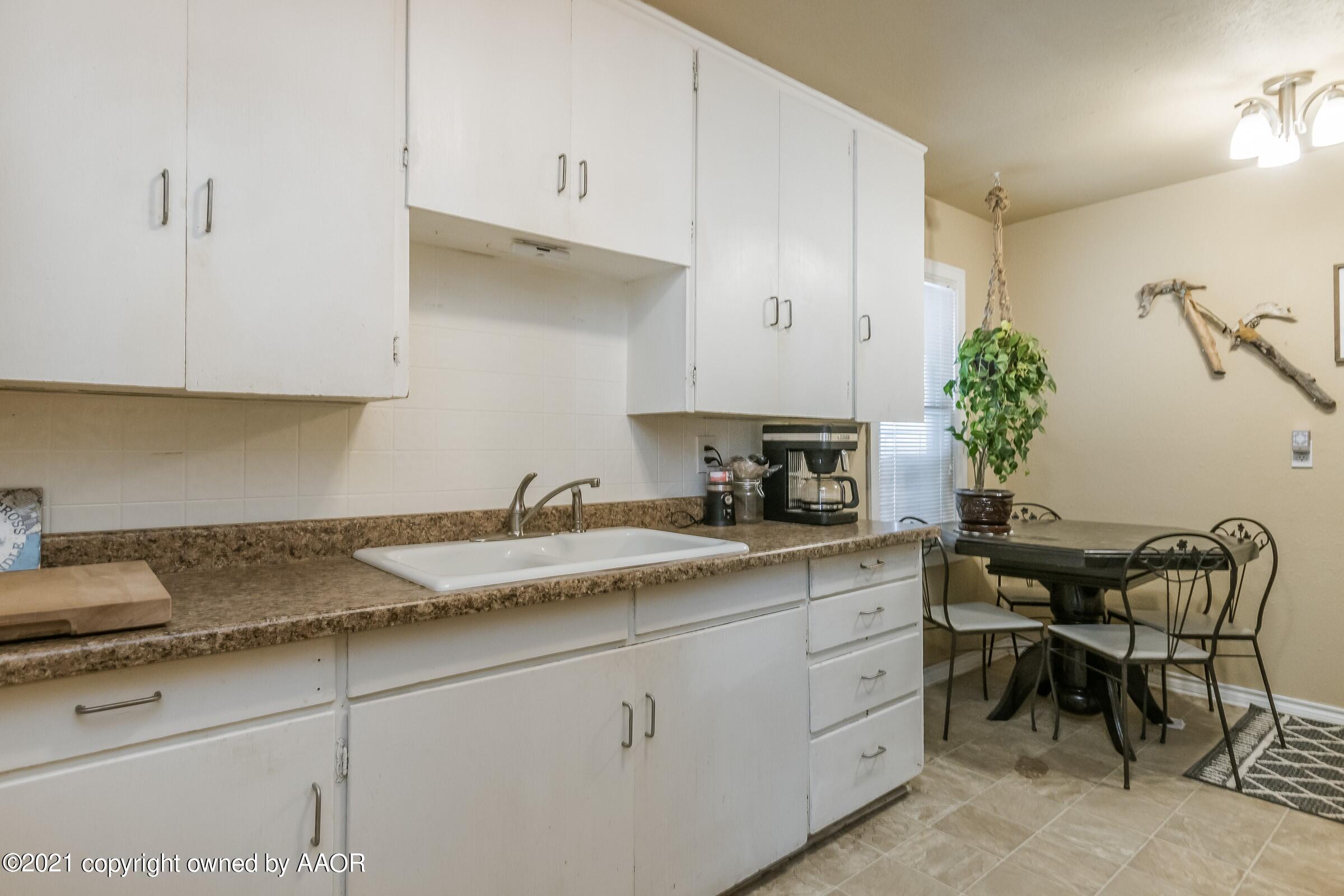 4100 South Ong Street Amarillo, TX 79110 - Photo 7 of 20 a kitchen with granite countertop white cabinets and white appliances