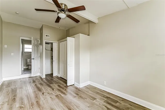 a view of empty room with wooden floor