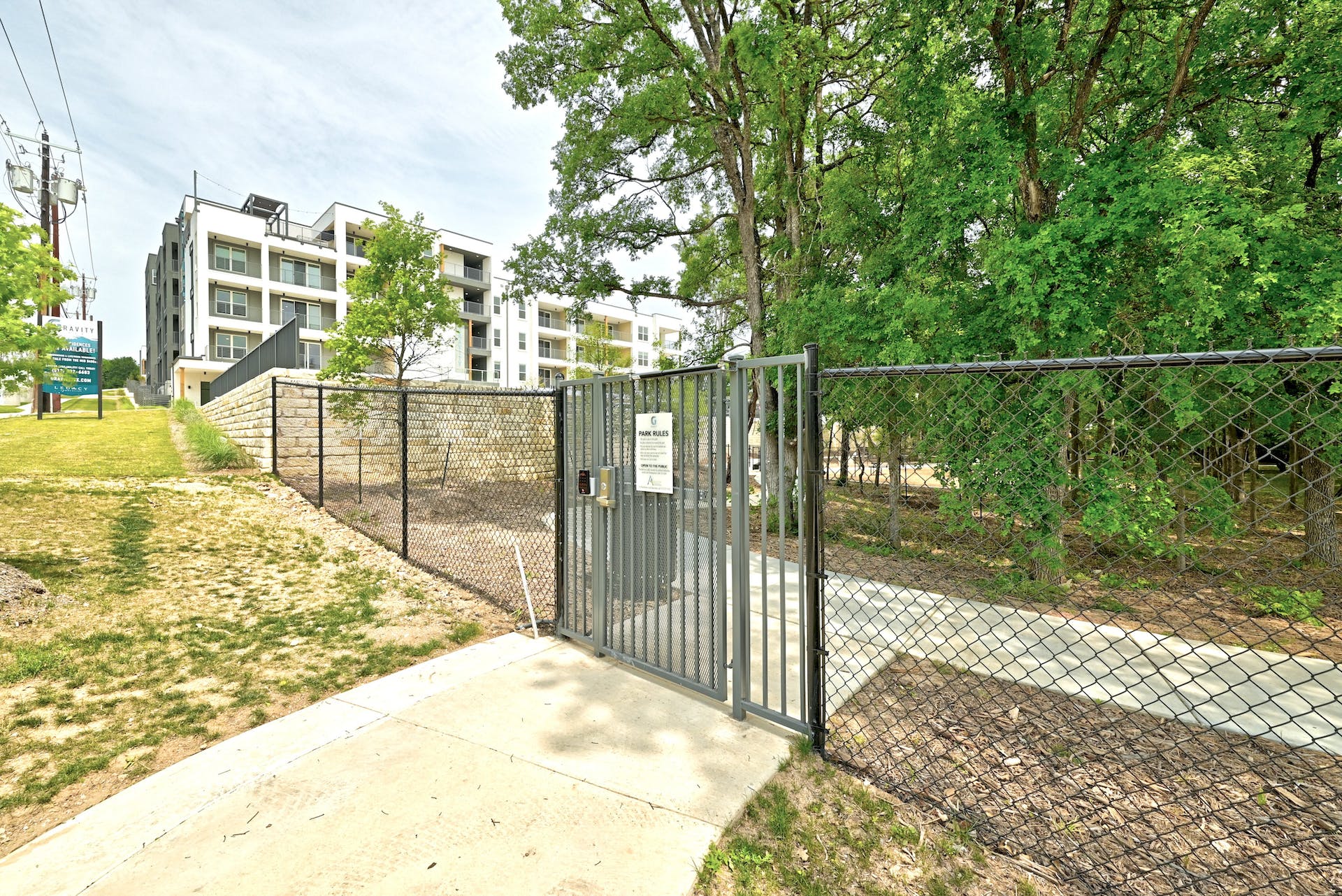4801 Springdale Road, Unit 1301 Austin, TX 78723 - Photo 38 of 39 Secure community access features a private entrance to a serene, tree-lined path.