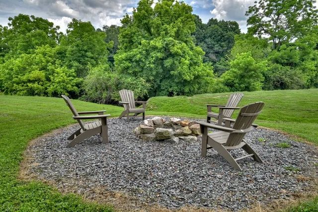 a wooden bench sitting in the grass near a forest