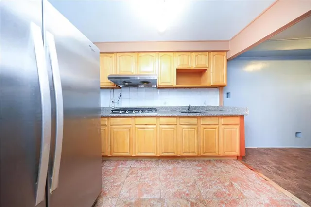 a kitchen with stainless steel appliances granite countertop a refrigerator and a sink
