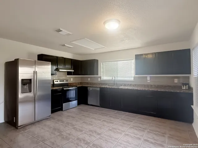 a large kitchen with cabinets and stainless steel appliances