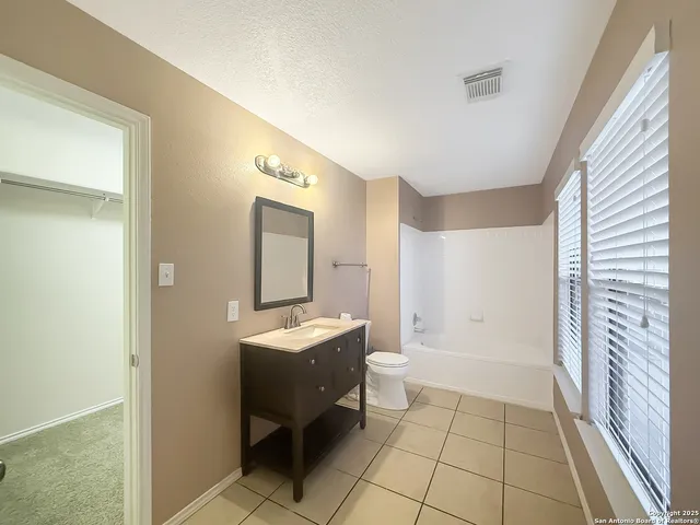 a view of an empty room with a chandelier fan