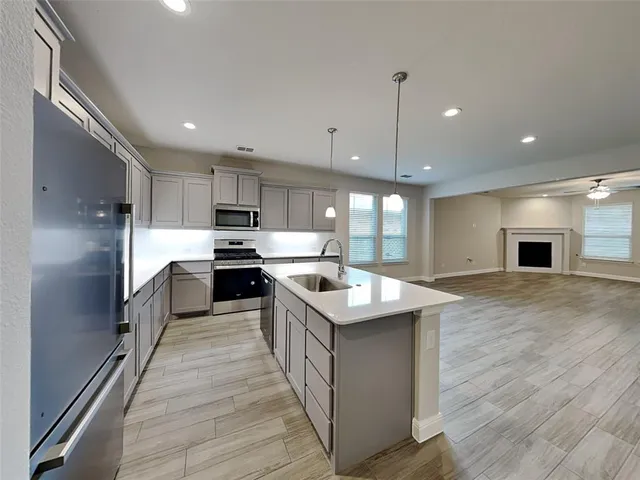 a kitchen with stainless steel appliances granite countertop a sink a stove and a refrigerator