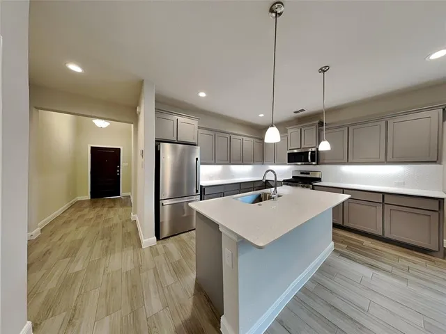 a kitchen with kitchen island a sink stainless steel appliances and kitchen island