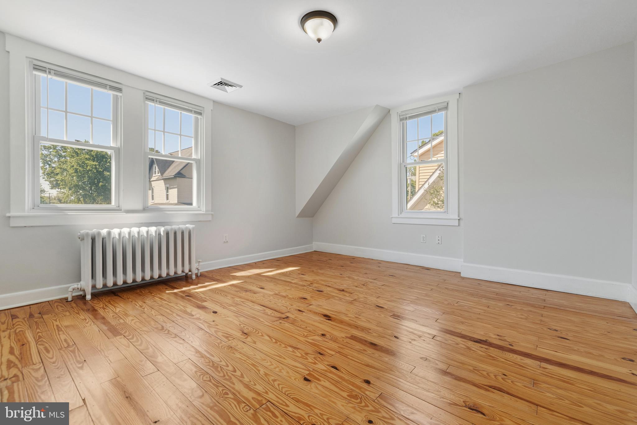 229 Wayne Avenue Narberth, PA 19072 - Photo 20 of 35 a view of an empty room with wooden floor and a window