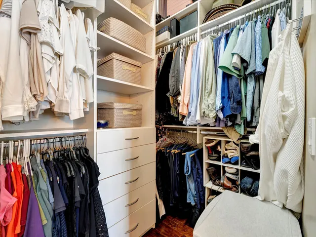 a view of walk in closet with clothes and shoes