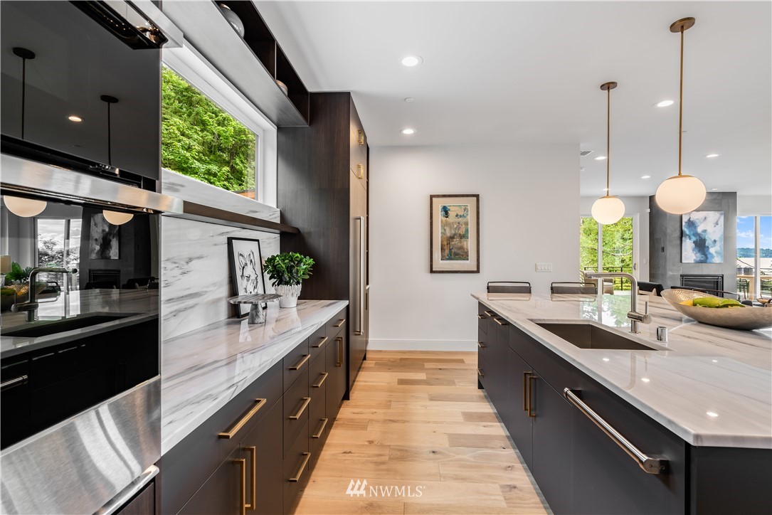 5616 Beach Drive Southwest Seattle, WA 98136 - Photo 12 of 40 a large kitchen with kitchen island a large counter top a sink and appliances