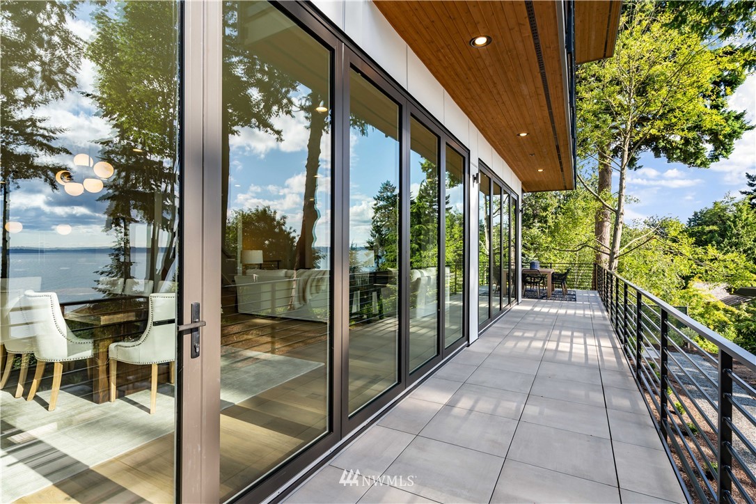 5616 Beach Drive Southwest Seattle, WA 98136 - Photo 32 of 40 a view of a porch with chairs and floor to ceiling window next to a yard