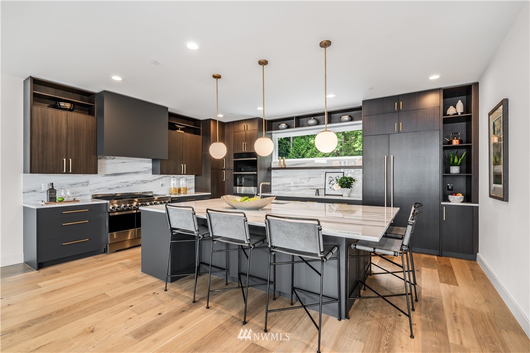 5616 Beach Drive Southwest Seattle, WA 98136 - Photo 10 of 40 a kitchen with stainless steel appliances granite countertop a stove top oven a sink dishwasher a dining table and chairs with wooden floor