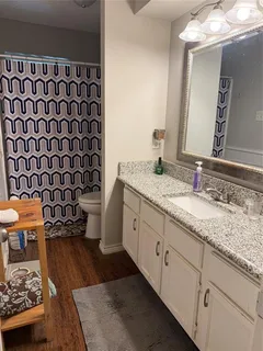 a spacious bathroom with a granite countertop sink and a mirror