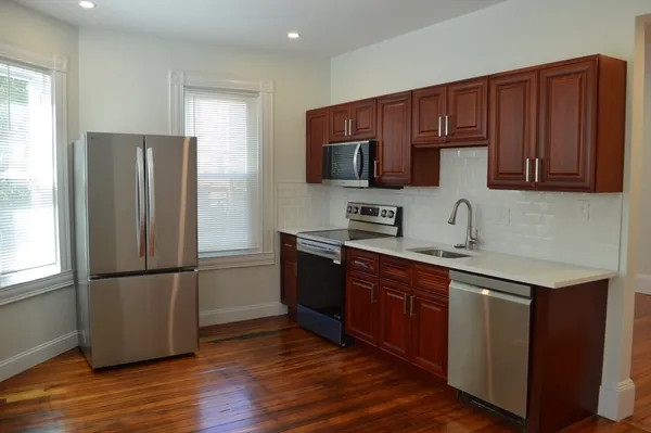 a kitchen with wooden cabinets and stainless steel appliances