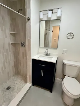 a bathroom with a sink vanity granite toilet and shower