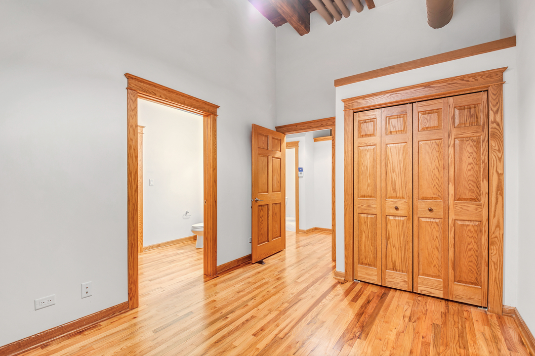 216 North May Street, Unit 103 Chicago, IL 60607 - Photo 12 of 21 an empty room with wooden floor and closet