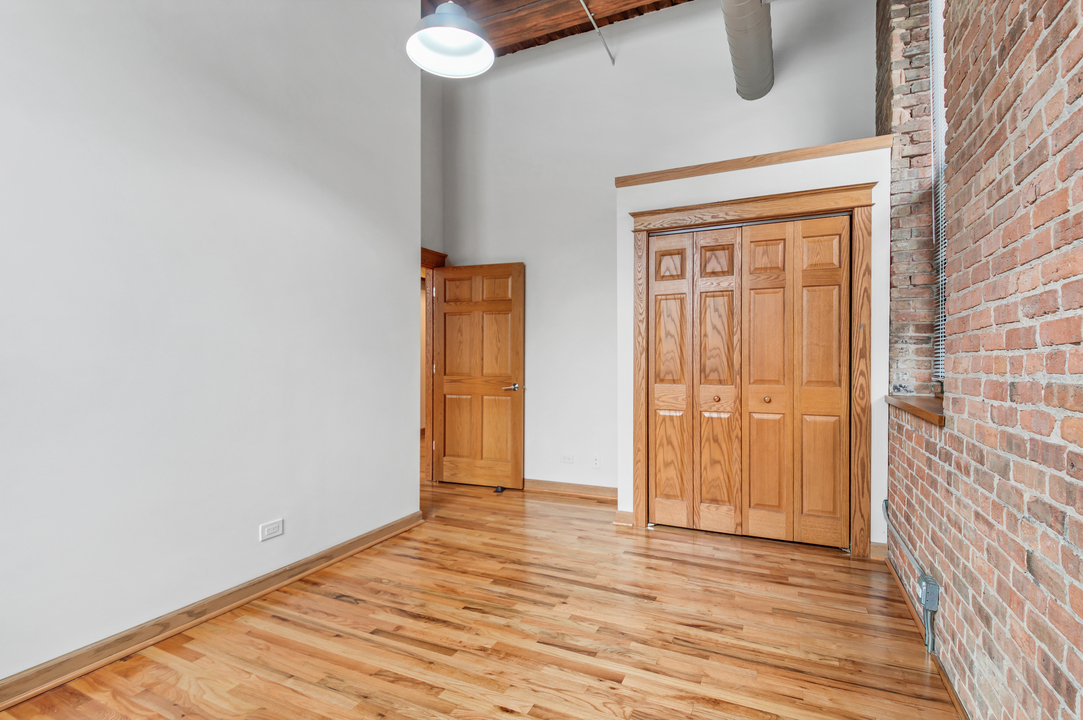 216 North May Street, Unit 103 Chicago, IL 60607 - Photo 14 of 21 a view of an empty room with wooden floor