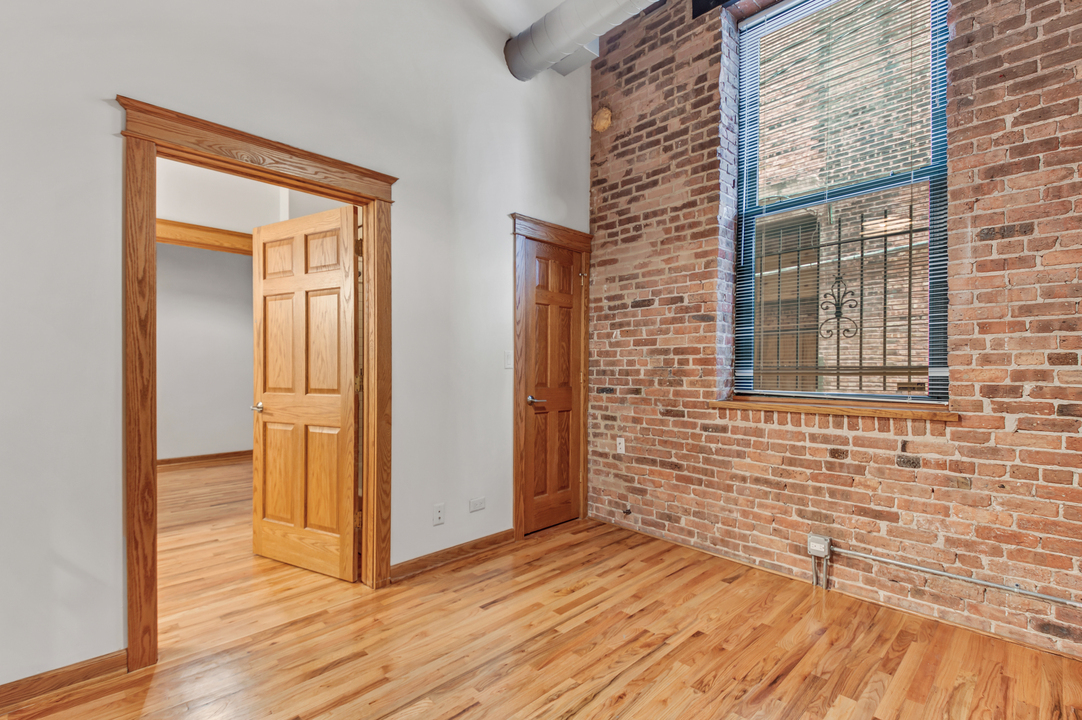 216 North May Street, Unit 103 Chicago, IL 60607 - Photo 15 of 21 a view of a brick house with wooden floor and a door