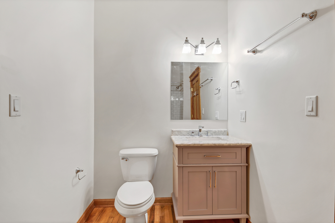 216 North May Street, Unit 103 Chicago, IL 60607 - Photo 17 of 21 a bathroom with a toilet sink vanity and mirror