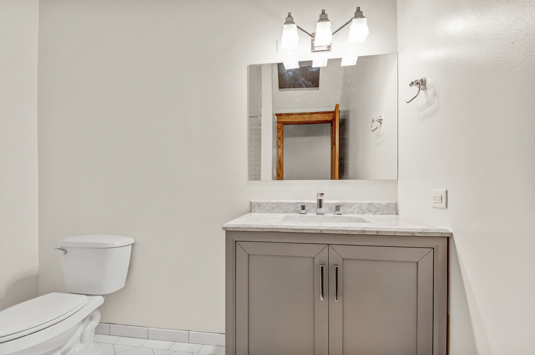216 North May Street, Unit 103 Chicago, IL 60607 - Photo 21 of 21 a bathroom with a toilet sink and mirror