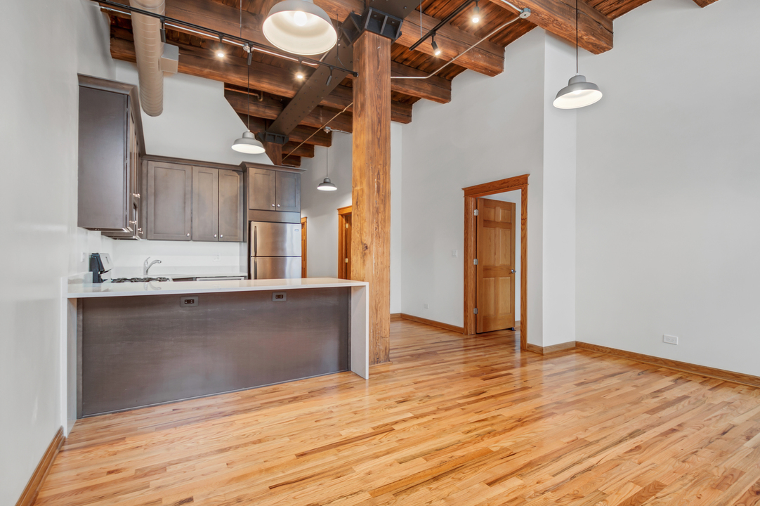216 North May Street, Unit 103 Chicago, IL 60607 - Photo 3 of 21 a view of kitchen and empty room with wooden floor