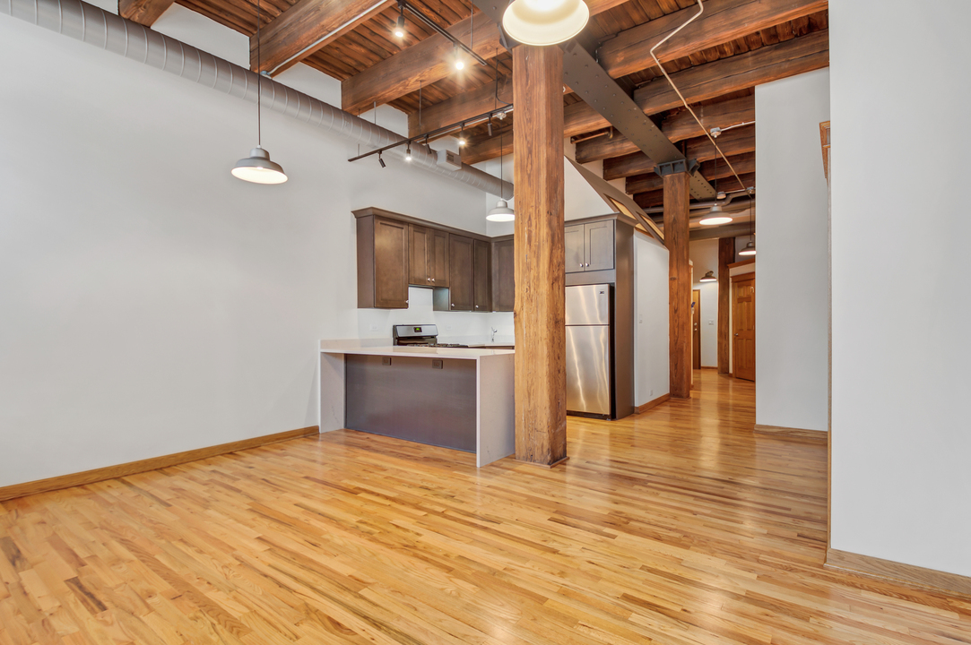 216 North May Street, Unit 103 Chicago, IL 60607 - Photo 4 of 21 a view of a kitchen with wooden floor and a kitchen space