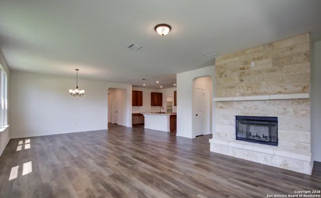 a view of empty room with wooden floor and fireplace