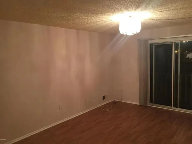 a view of a small space with wooden floor and a window