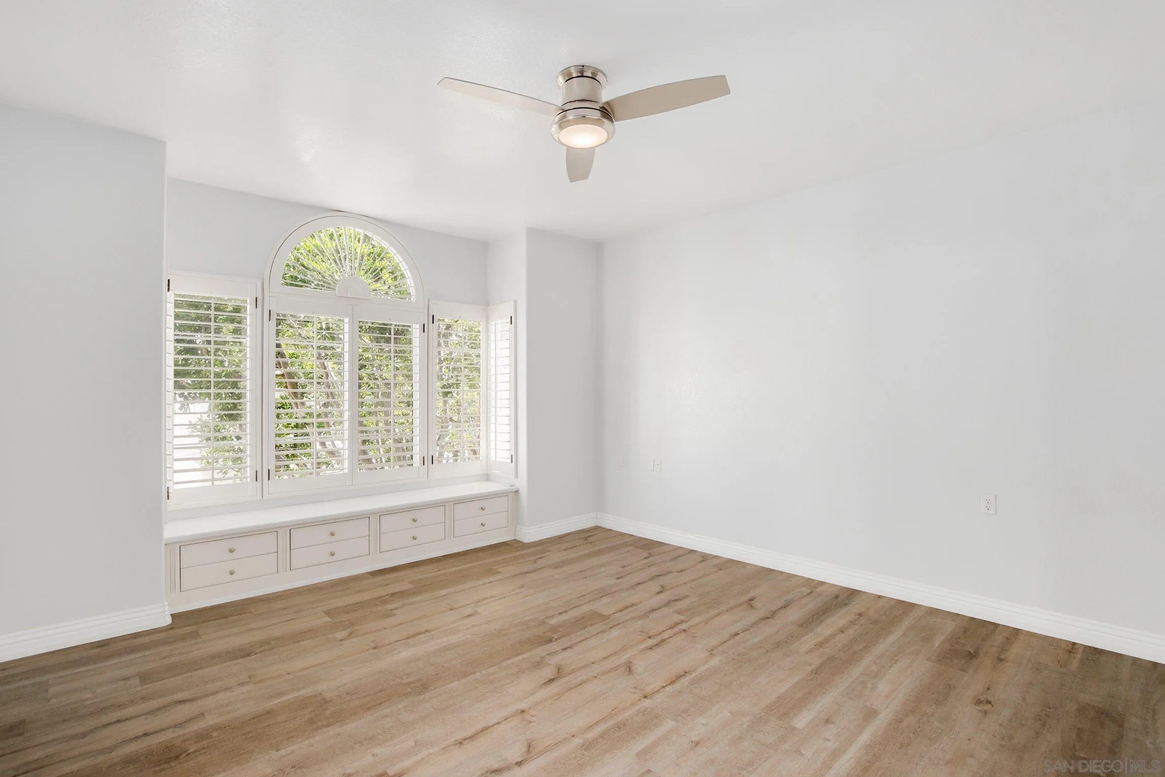 3355 Genoa Way, Unit 134 Oceanside, CA 92056 - Photo 19 of 32 an empty room with wooden floor exposed radiator and windows