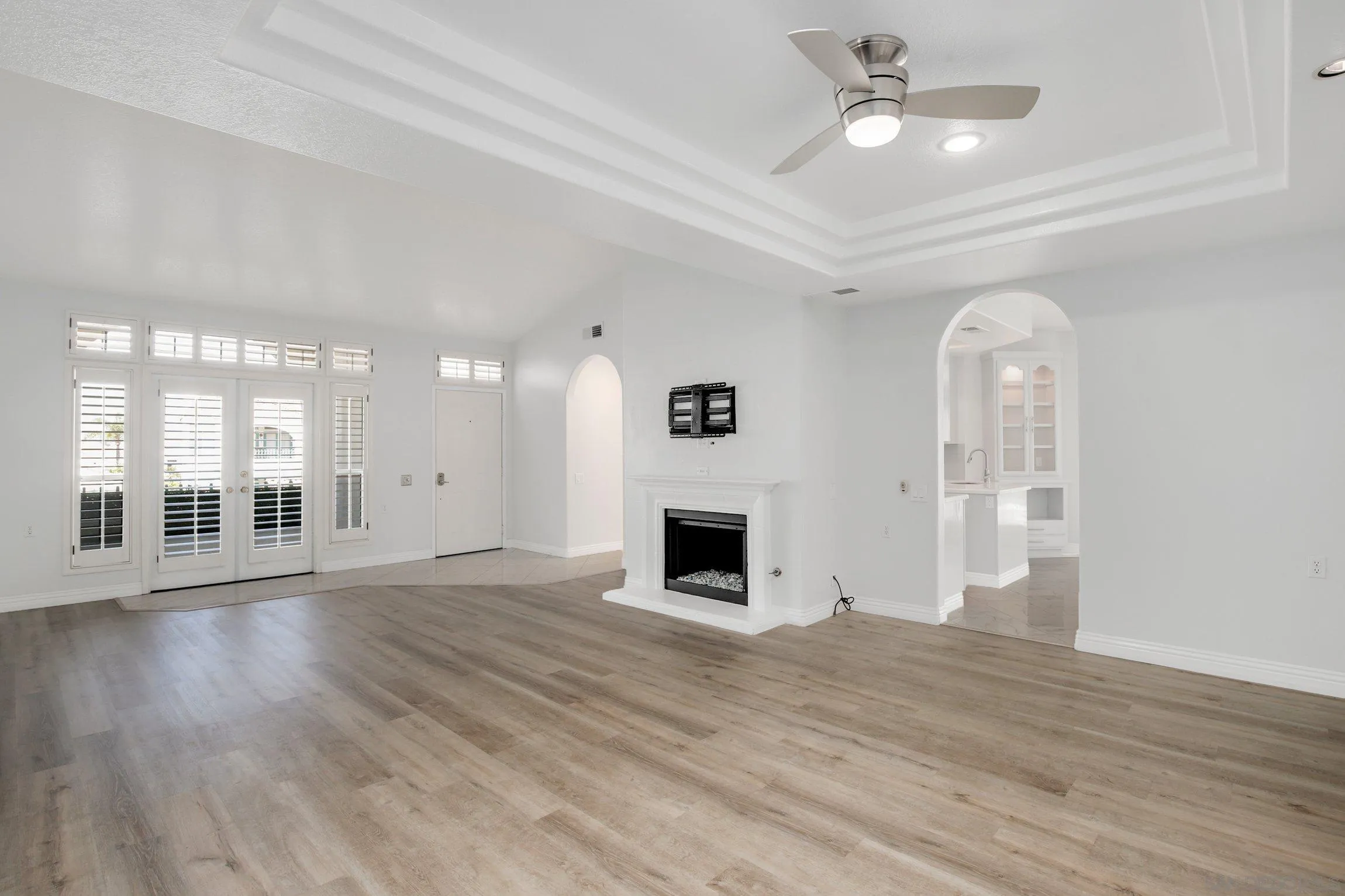 3355 Genoa Way, Unit 134 Oceanside, CA 92056 - Photo 2 of 32 an empty room with wooden floor fireplace and windows