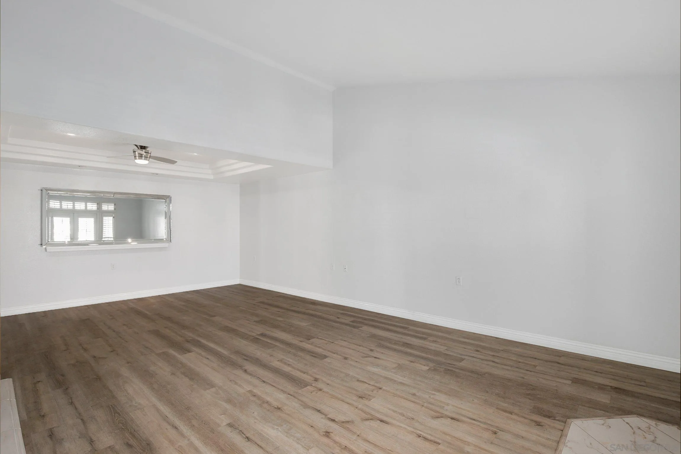 3355 Genoa Way, Unit 134 Oceanside, CA 92056 - Photo 4 of 32 an empty room with wooden floor and windows