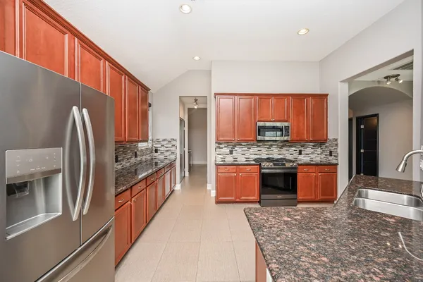 an empty room with wooden floor ceiling fan and windows