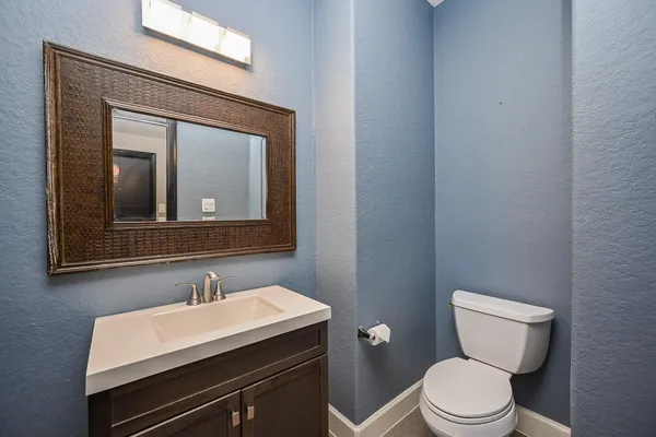 a en suite bathroom with a granite countertop sink and a mirror