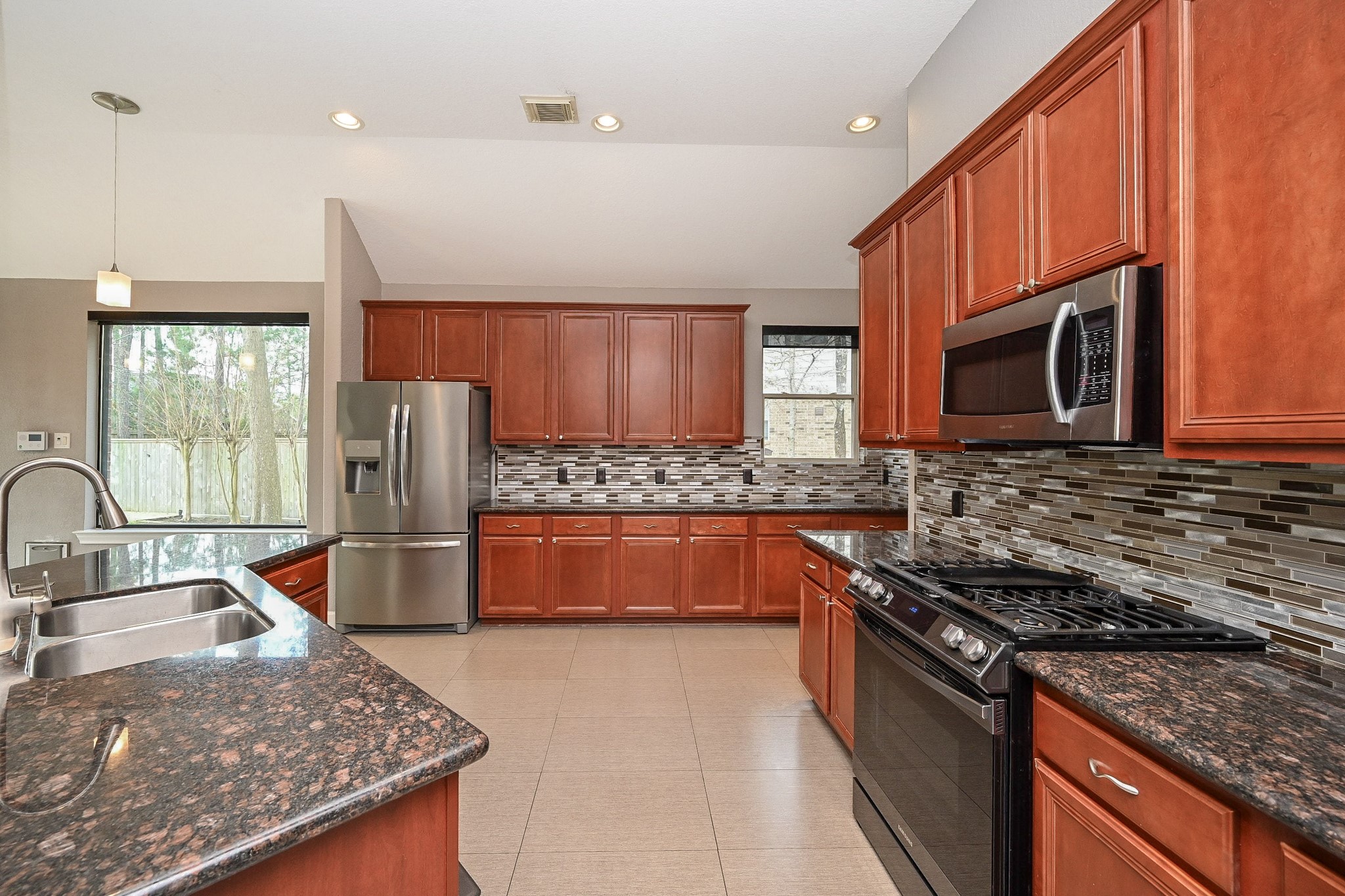 146 Rocky Point Drive Spring, TX 77389 - Photo 10 of 37 a kitchen with stainless steel appliances granite countertop a stove a sink and a microwave