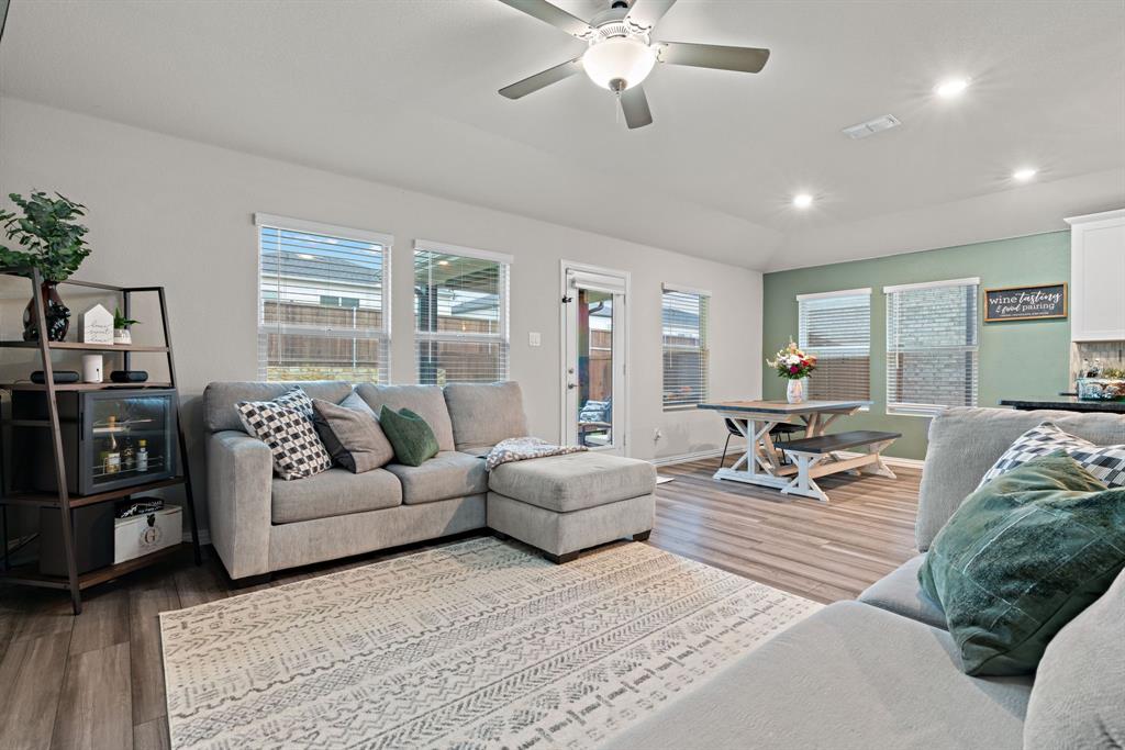 3112 Kingsgarden Road Denton, TX 76207 - Photo 7 of 38 Open-concept living area featuring wood-finish flooring, a ceiling fan with integrated lighting, recessed lighting, multiple windows with blinds, and a glass-paneled exterior door