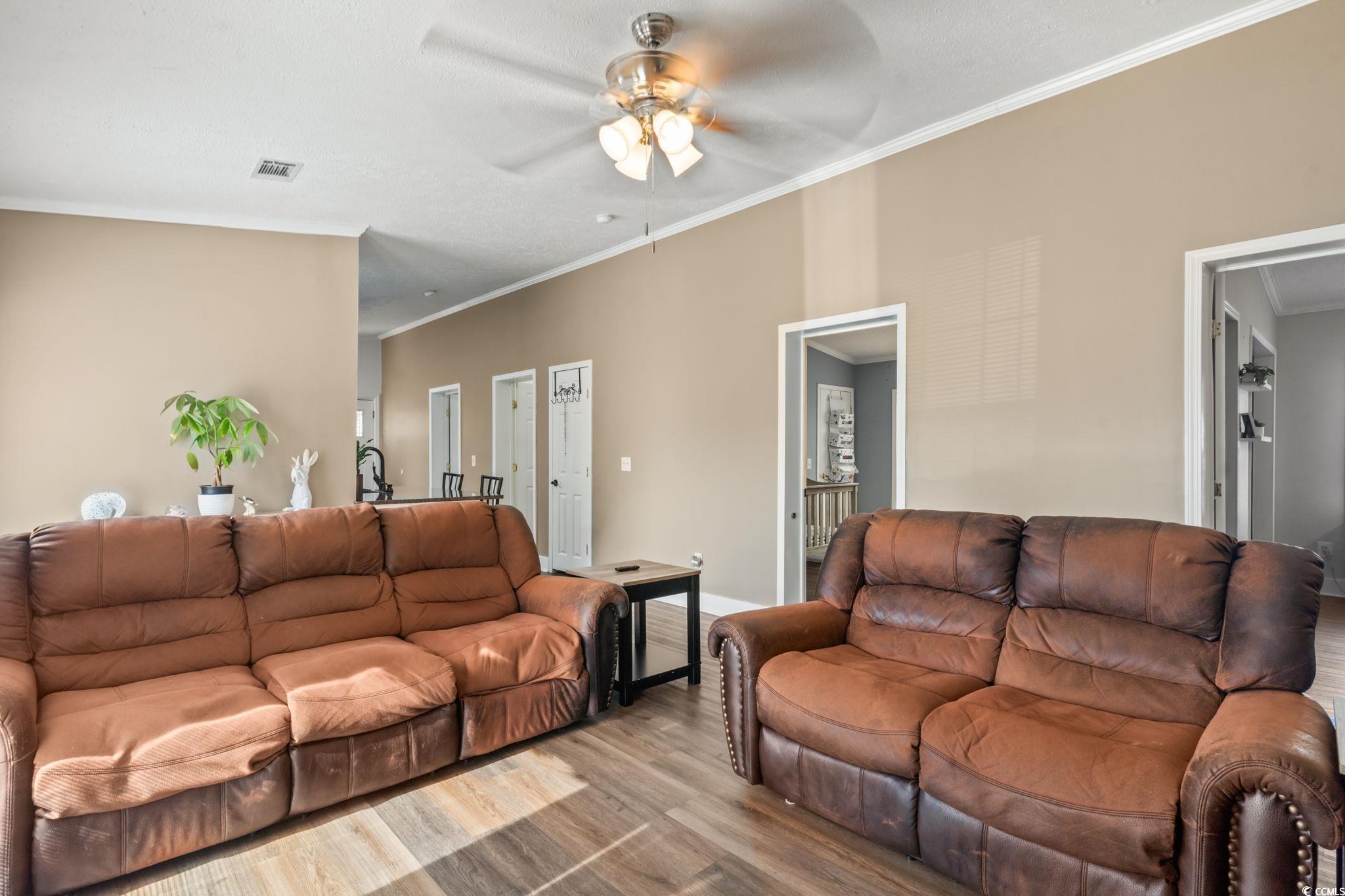 2977 Silverleaf Circle Loris, SC 29569 - Photo 12 of 36 Living area with ornamental molding, wood finished floors, and a ceiling fan