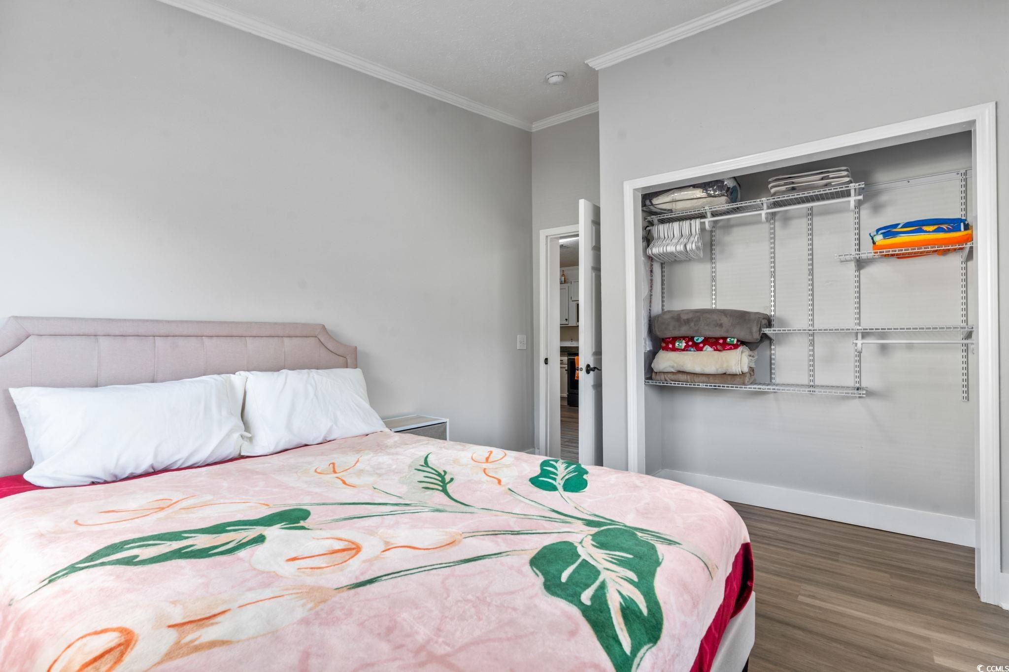 2977 Silverleaf Circle Loris, SC 29569 - Photo 16 of 36 Bedroom featuring a closet, crown molding, and dark wood-style floors
