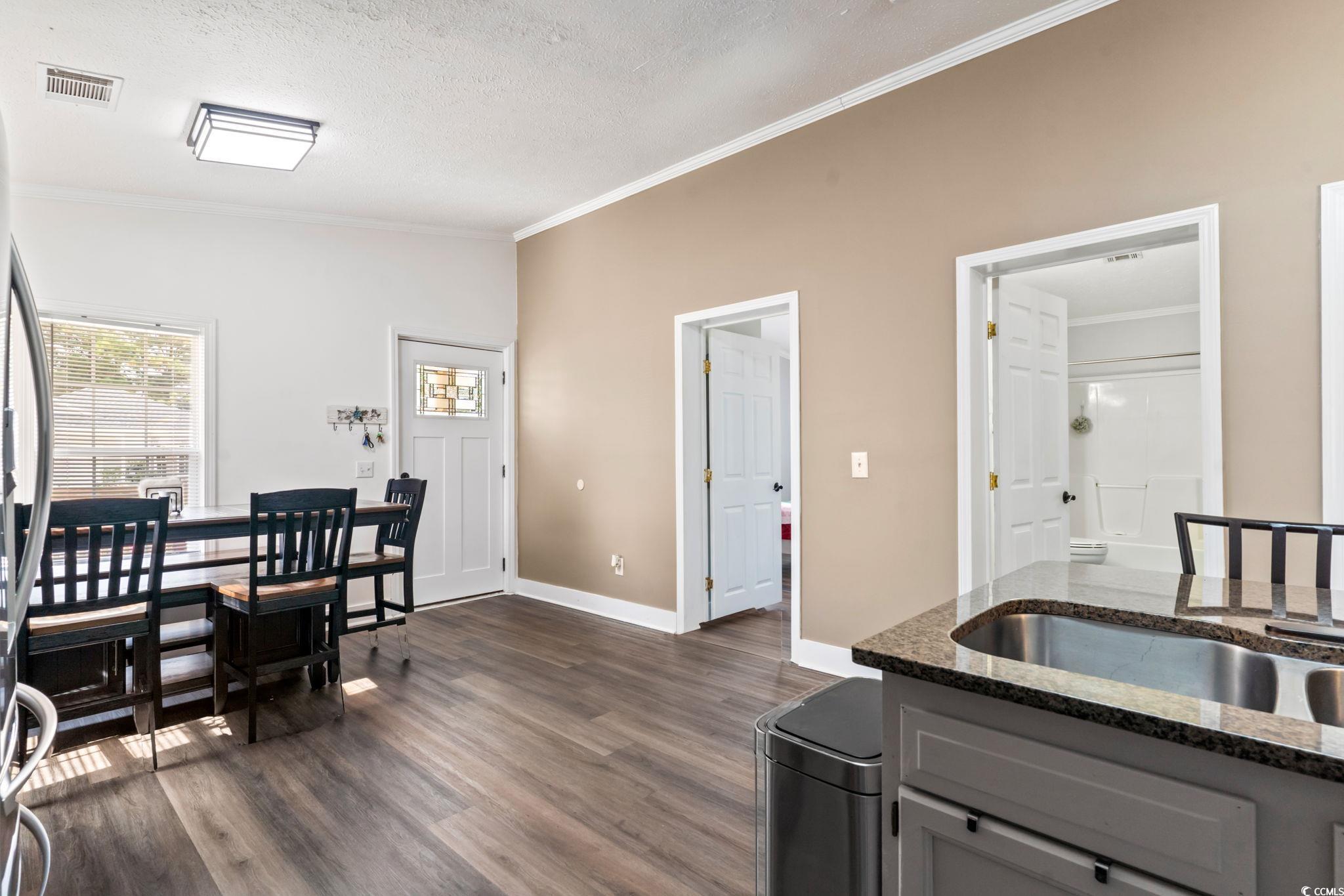 2977 Silverleaf Circle Loris, SC 29569 - Photo 4 of 36 Kitchen with gray cabinetry, ornamental molding, dark stone counters, dark wood finished floors, and a textured ceiling