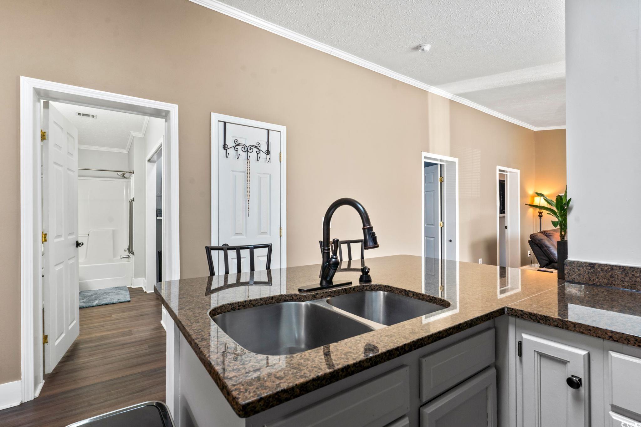2977 Silverleaf Circle Loris, SC 29569 - Photo 7 of 36 Kitchen with ornamental molding, dark wood-style flooring, gray cabinets, a peninsula, and dark stone countertops