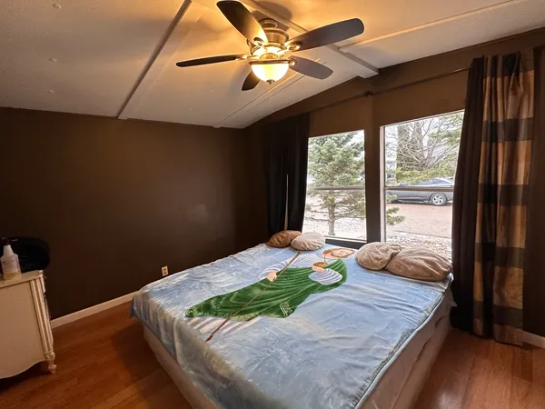 a bedroom with a bed and a large window