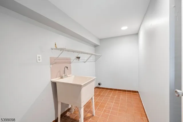 a view of an empty room with wooden floor and a ceiling fan