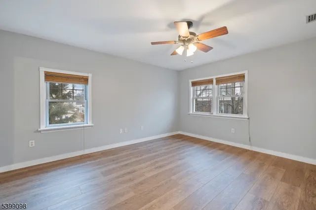 a view of an empty room with wooden floor