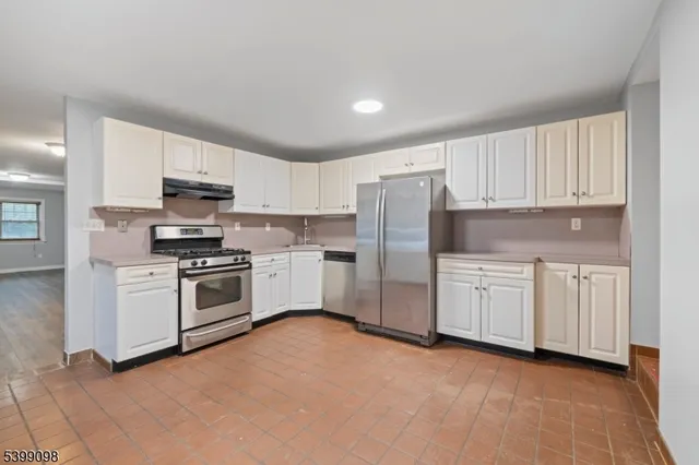 a kitchen with granite countertop white cabinets and stainless steel appliances