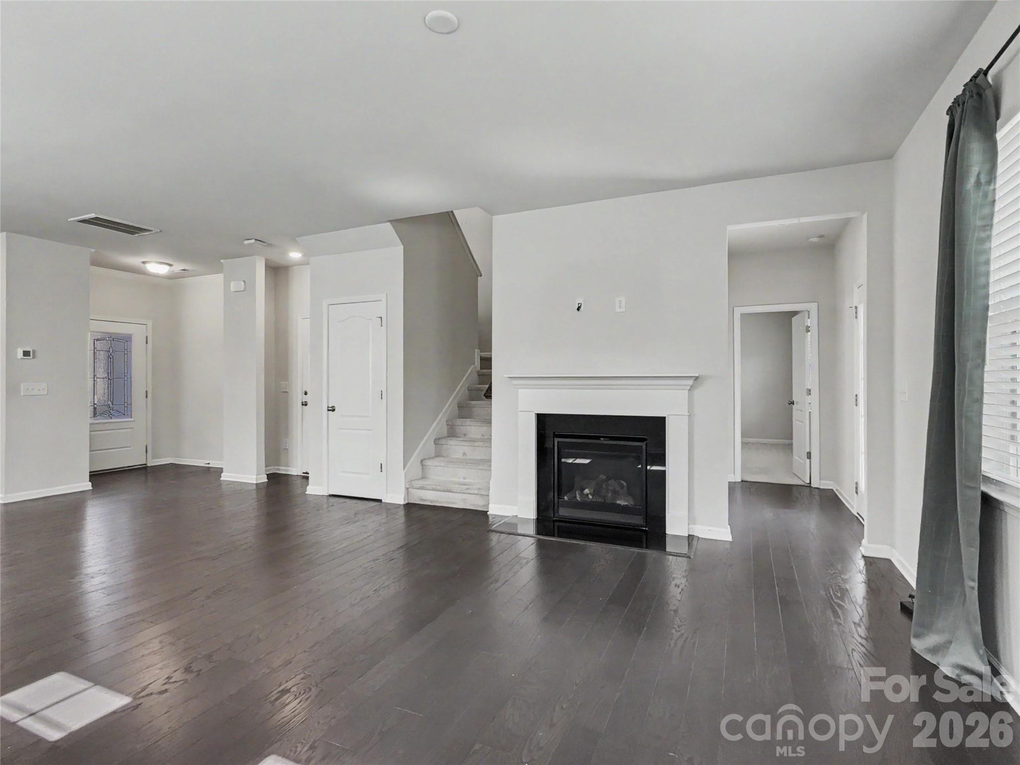 16835 Cozy Cove Road Charlotte, NC 28278 - Photo 12 of 32 a view of an empty room with wooden floor fireplace and a window