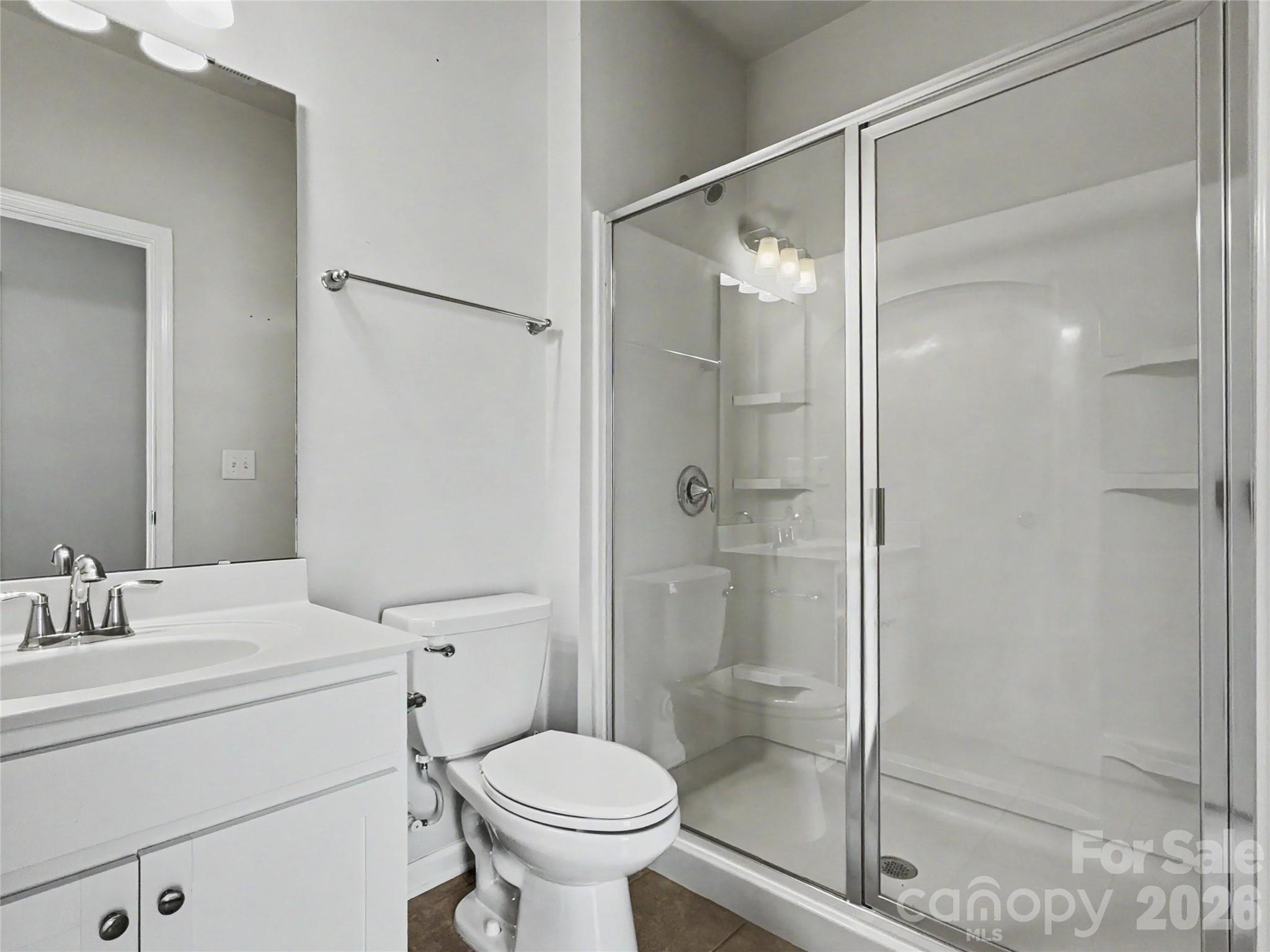 16835 Cozy Cove Road Charlotte, NC 28278 - Photo 14 of 32 a bathroom with a shower sink vanity mirror and toilet