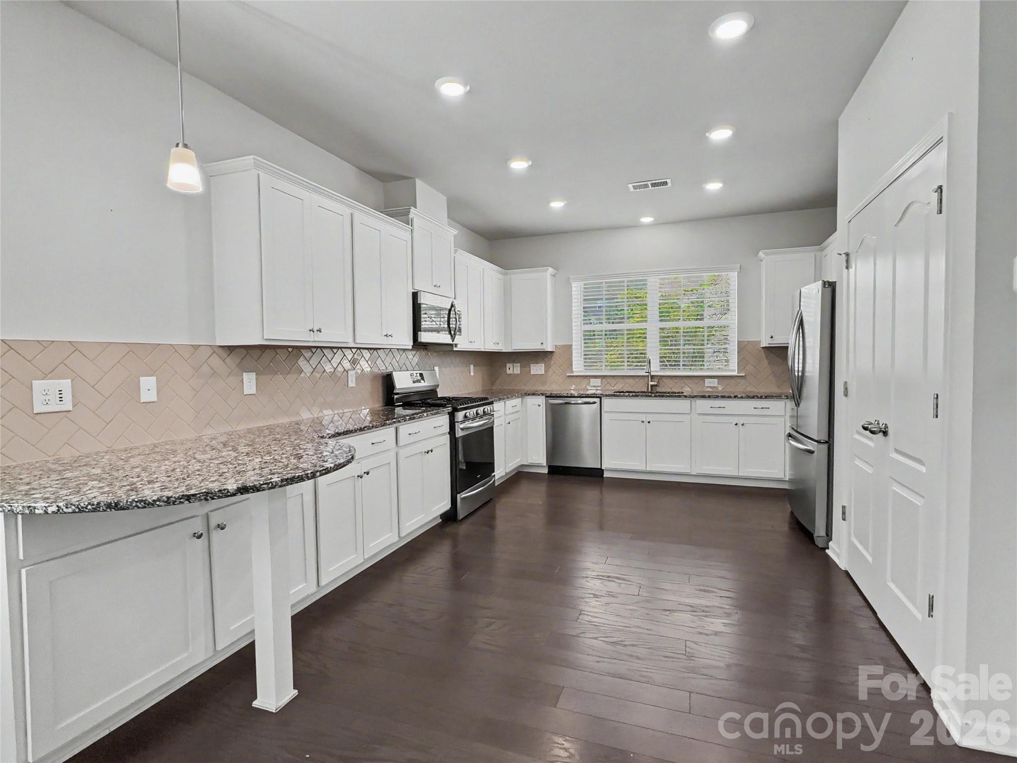 16835 Cozy Cove Road Charlotte, NC 28278 - Photo 5 of 32 a kitchen with granite countertop white cabinets and white appliances